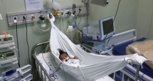 A pequena indígena Alciane Saw Munduruku, de apenas 10 meses, estava internada no Hospital das Clínicas Gaspar Viana desde o dia 14 de junho para tratar uma cardiopatia. Ela não conseguia dormir no leito, e o choro também colocava em risco o sono dos vizinhos de UTI. Foi quando a técnica em enfermagem Deusiane Costa teve a iniciativa de improvisar uma pequena rede (foto) com um lençol armado sobre a cama. Não demorou muito para Alciane se acalmar, relembrar o conforto de casa e dormir. O ato é um dos exemplos do tratamento humanizado oferecido pelos hospitais estaduais. FOTO: ASCOM / HOSPITAL GASPAR VIANA. DATA: 05.07.2016 BELÉM - PARÁ